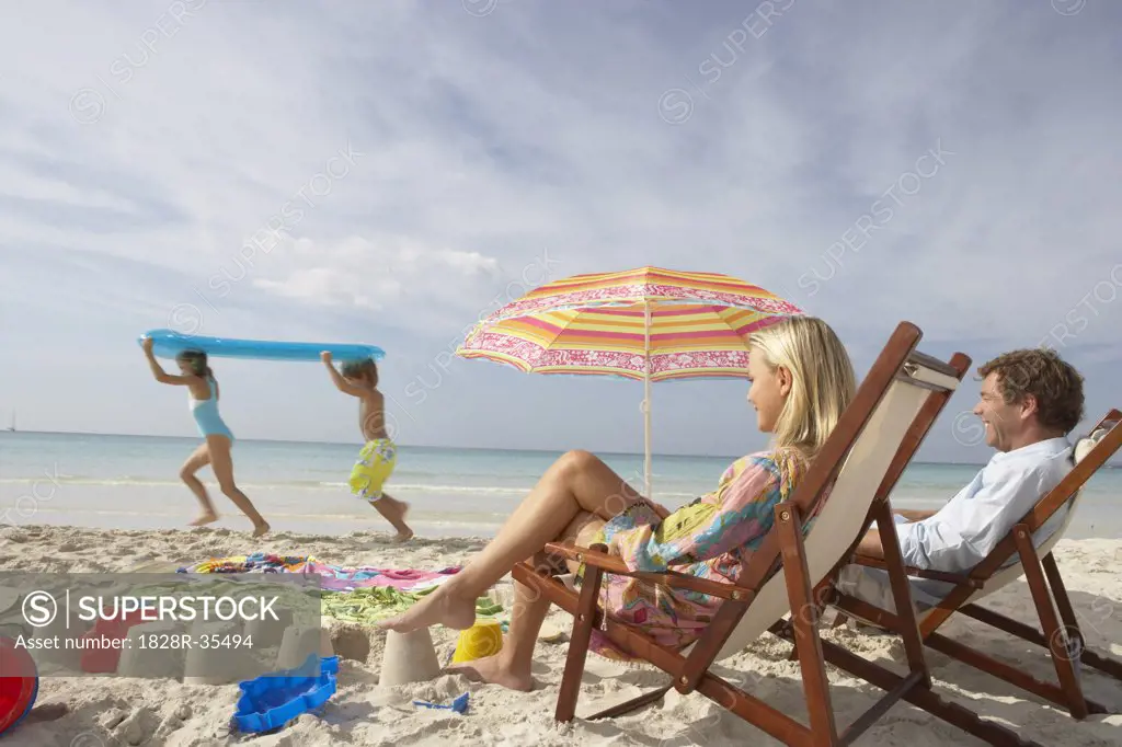 Parents Watching Children Play on Beach, Majorca, Spain   