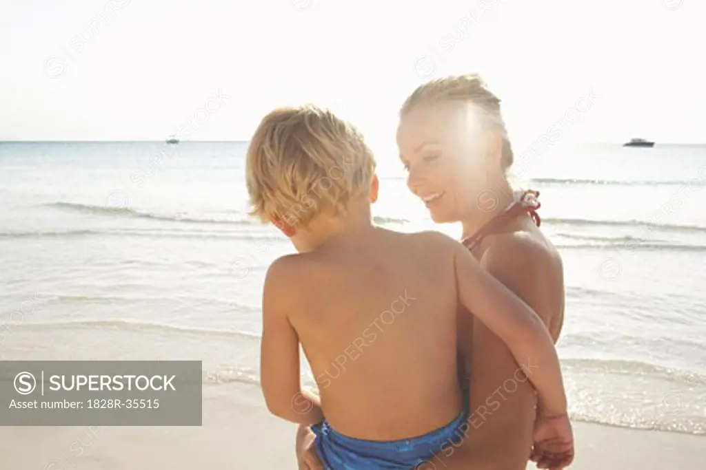 Mother Carrying Son on Beach, Majorca, Spain   