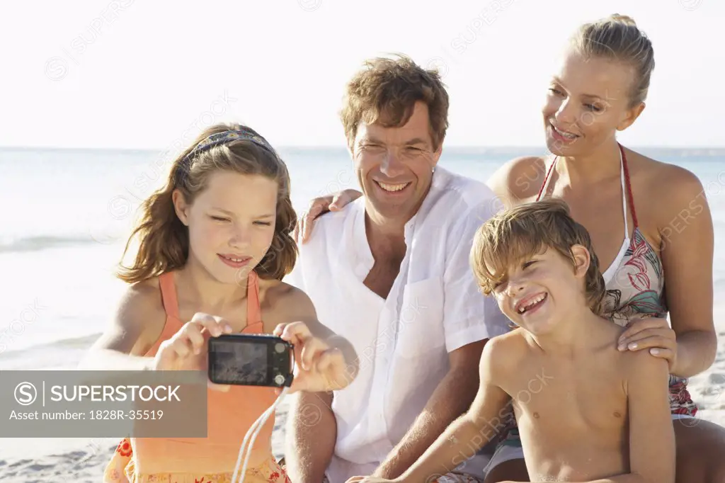 Girl Taking Portrait of Family on Beach, Majorca, Spain   