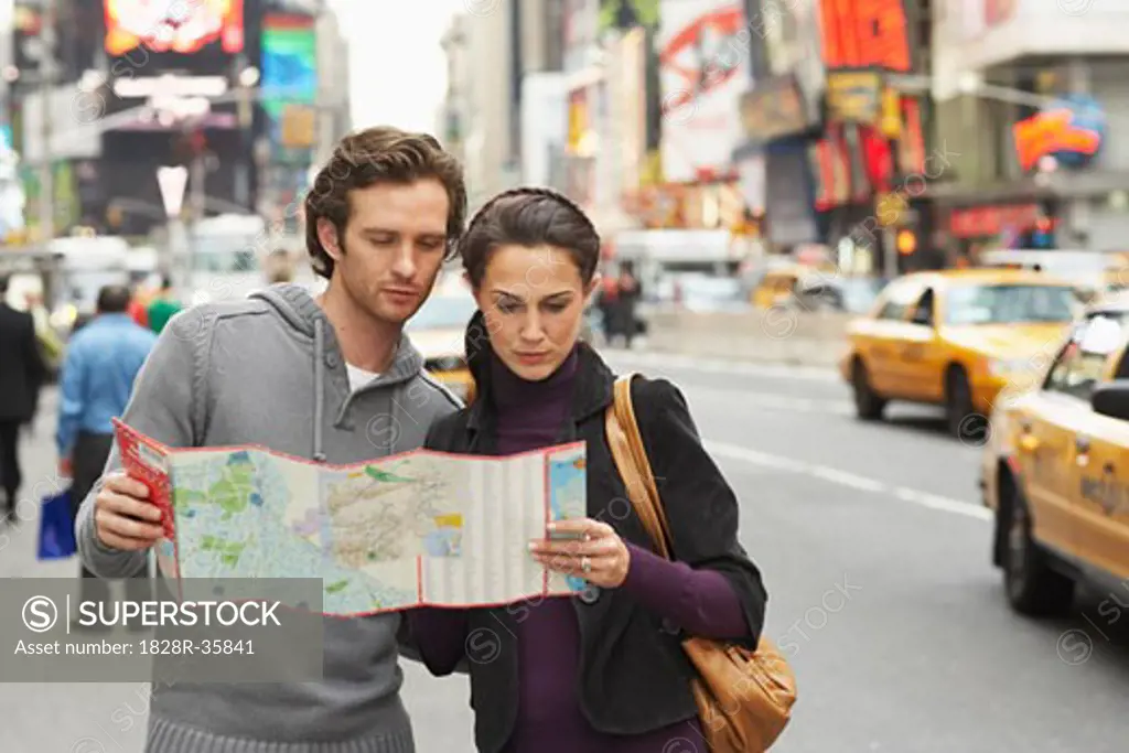 Couple in City with Map, New York City, New York, USA   