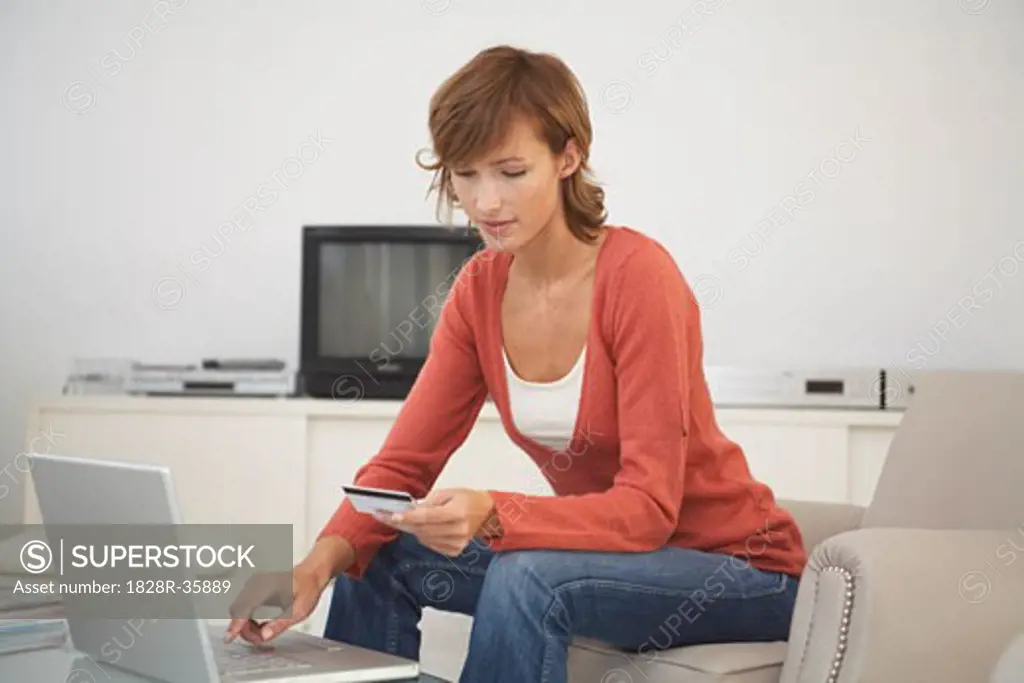 Woman in Living Room with Credit Card and Laptop Computer   