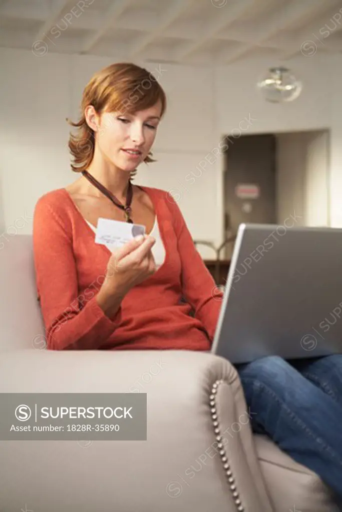 Woman in Chair with Credit Card and Laptop Computer   