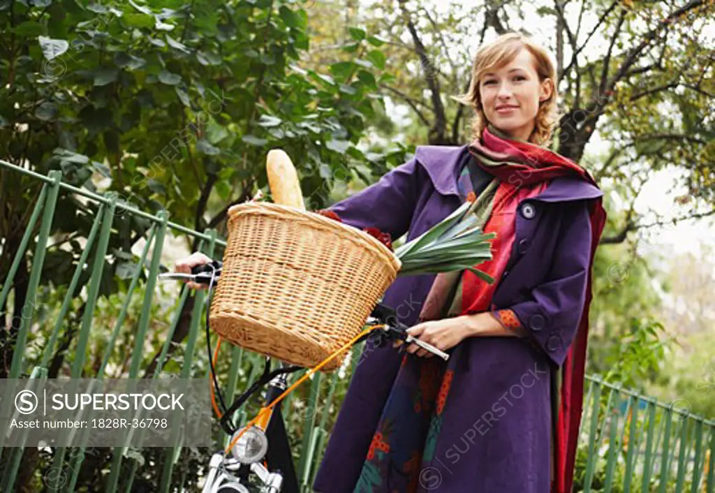 Woman Standing with Bicycle and Basket Full of Groceries   