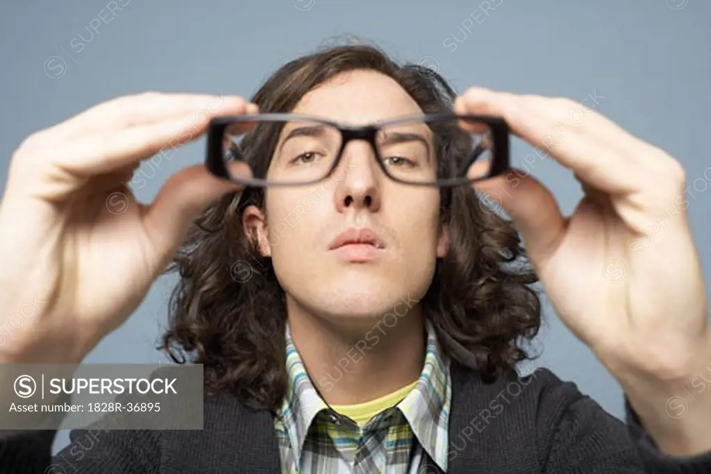 Portrait of Man Holding Eyeglasses   