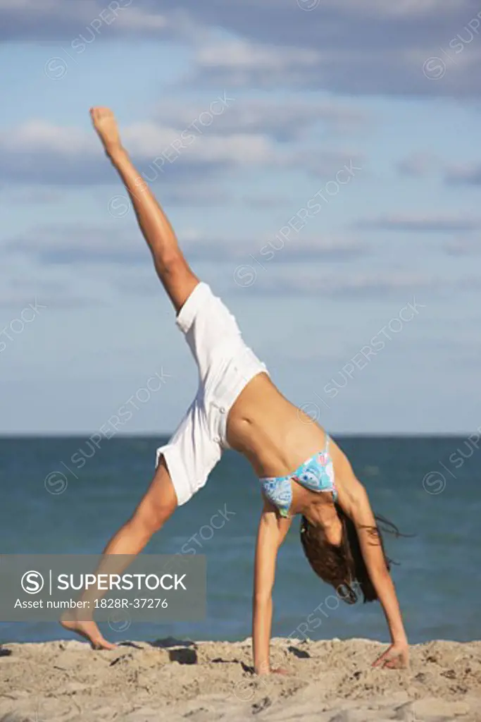 Girl Doing Cartwheel on Beach   