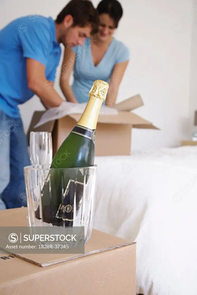 Couple in New Home with Boxes and Champagne   