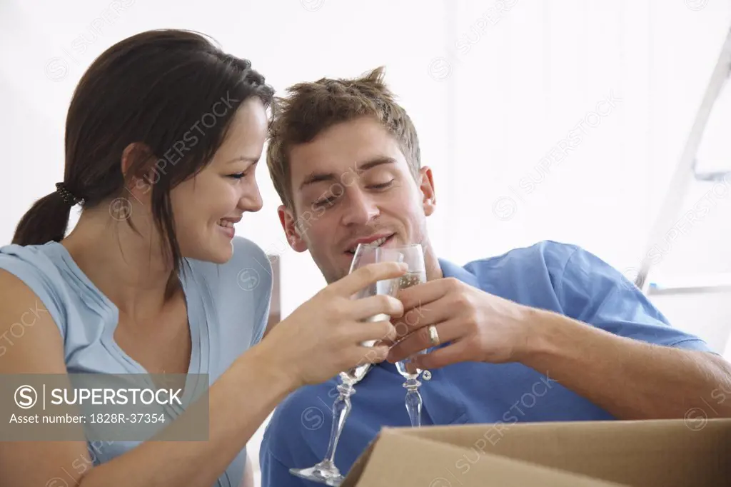 Couple in New Home with Boxes and Champagne   