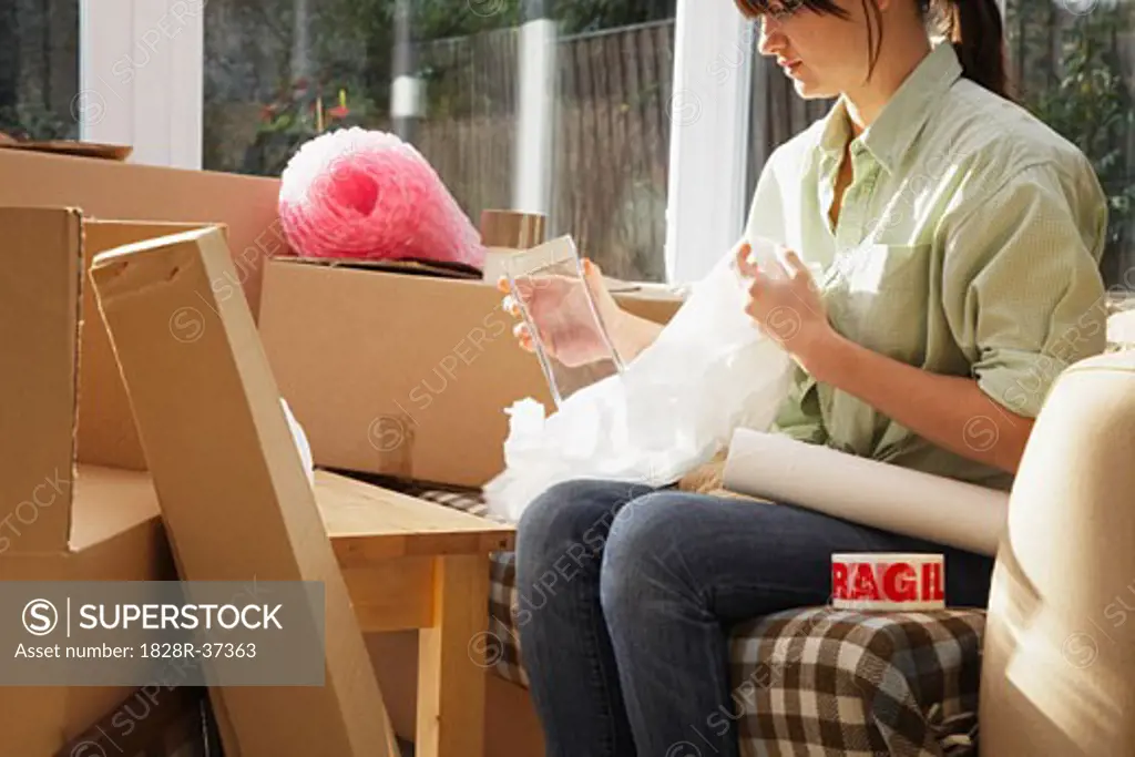 Woman Packing Boxes in Sunroom   
