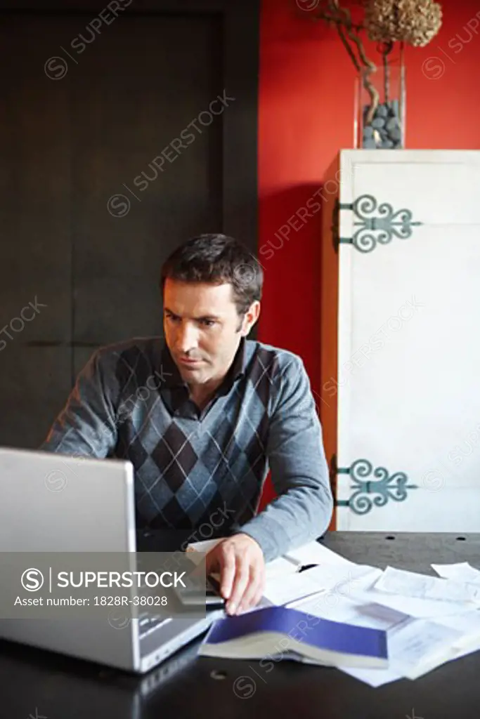 Man with Laptop and Paperwork   