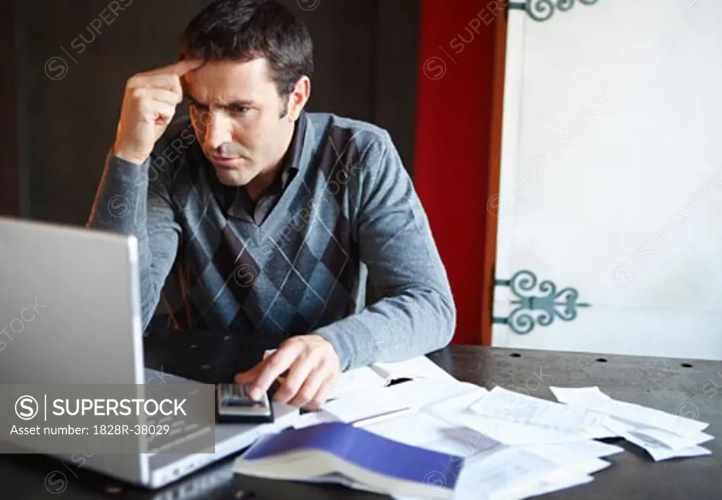 Man with Laptop and Paperwork   