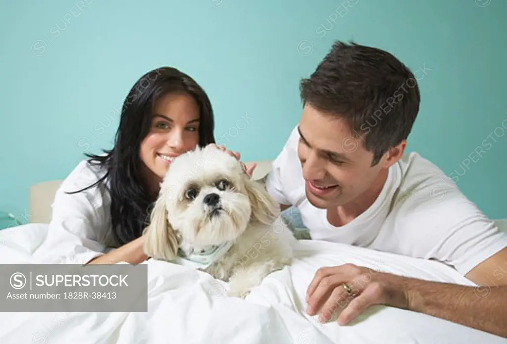 Couple with Dog on Bed   