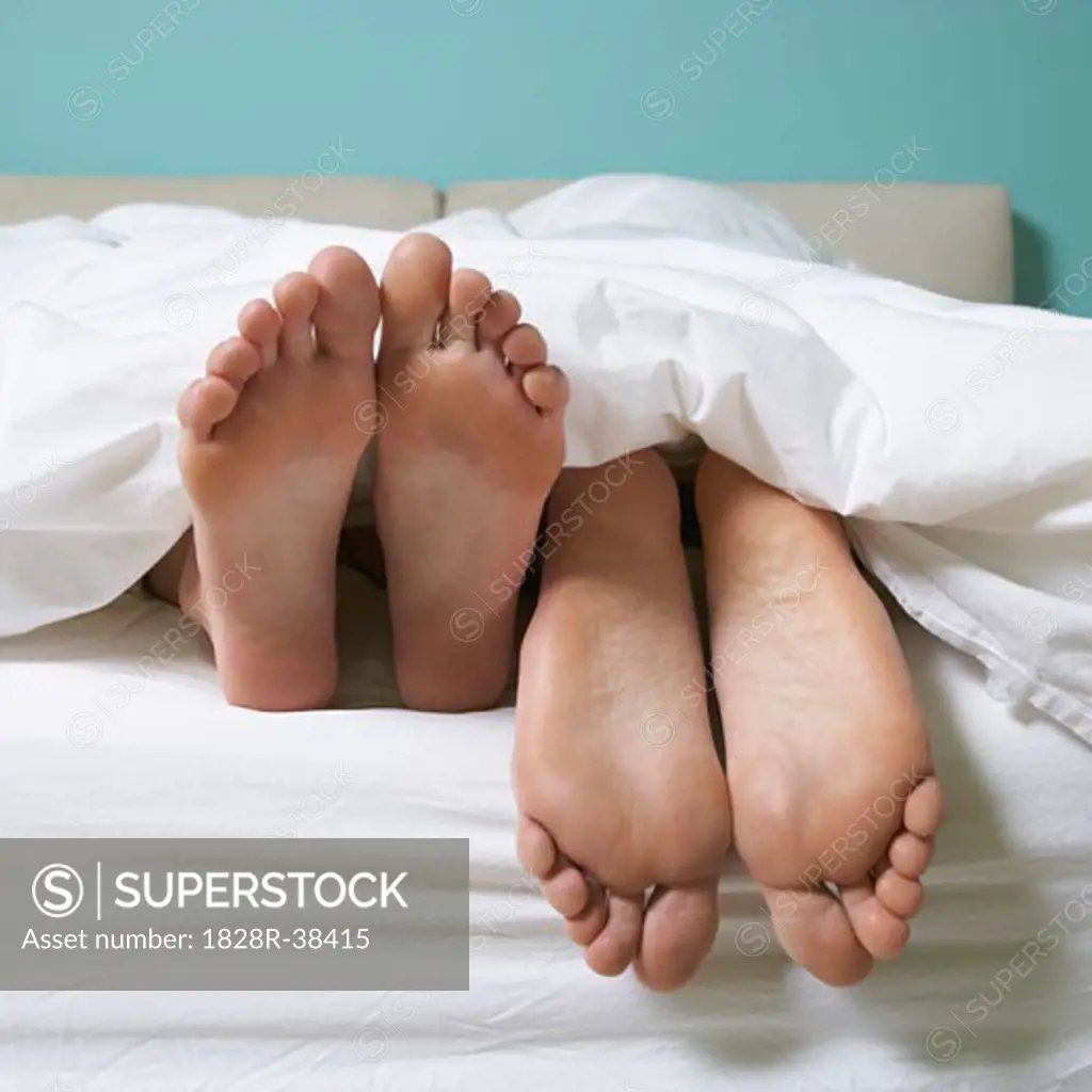 Couple's Feet in Bed   