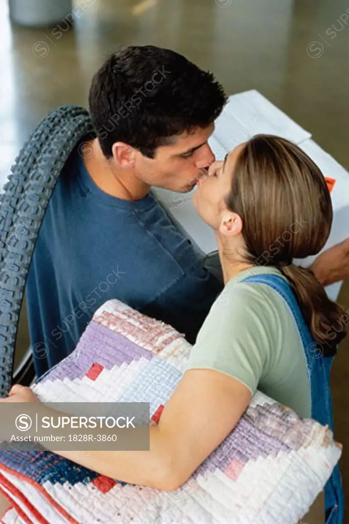 Couple Kissing while Moving into New Home   