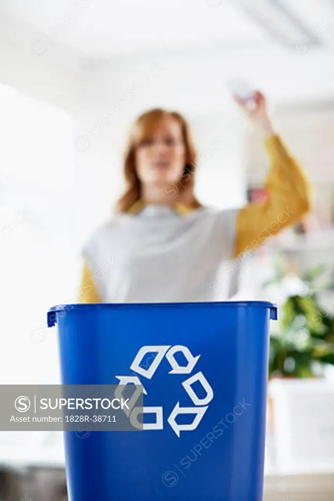 Woman Tossing Paper into Recycling Bin   