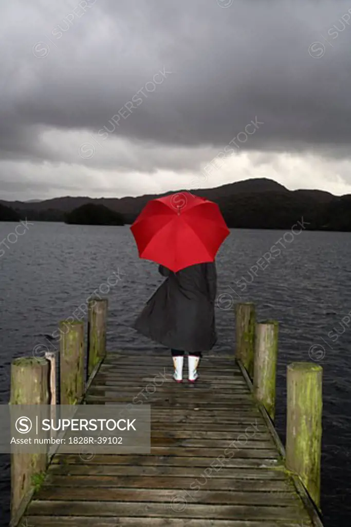 Girl on Dock in Rain, Lake Windermere, Cumbria, England   