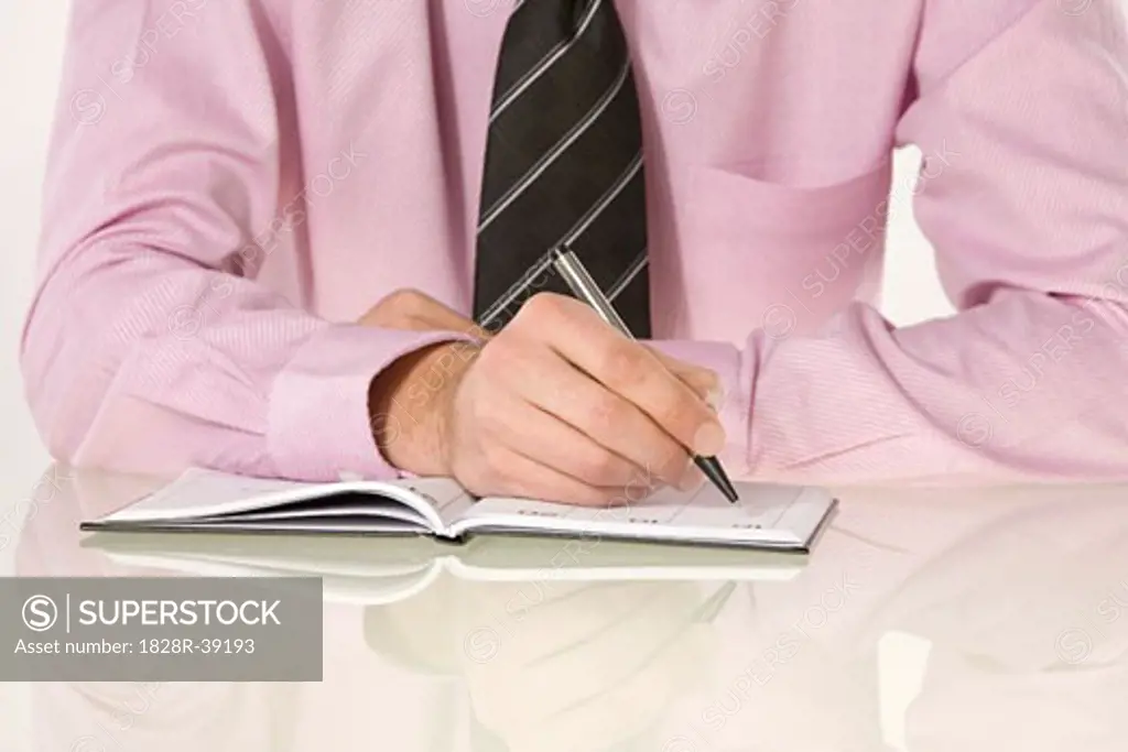 Close-up of Businessman Writing in Appointment Book   