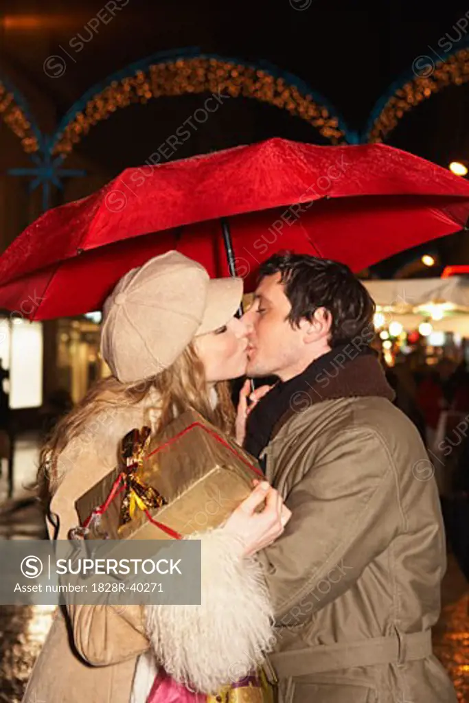 Couple Christmas Shopping, Kissing Under Umbrella   