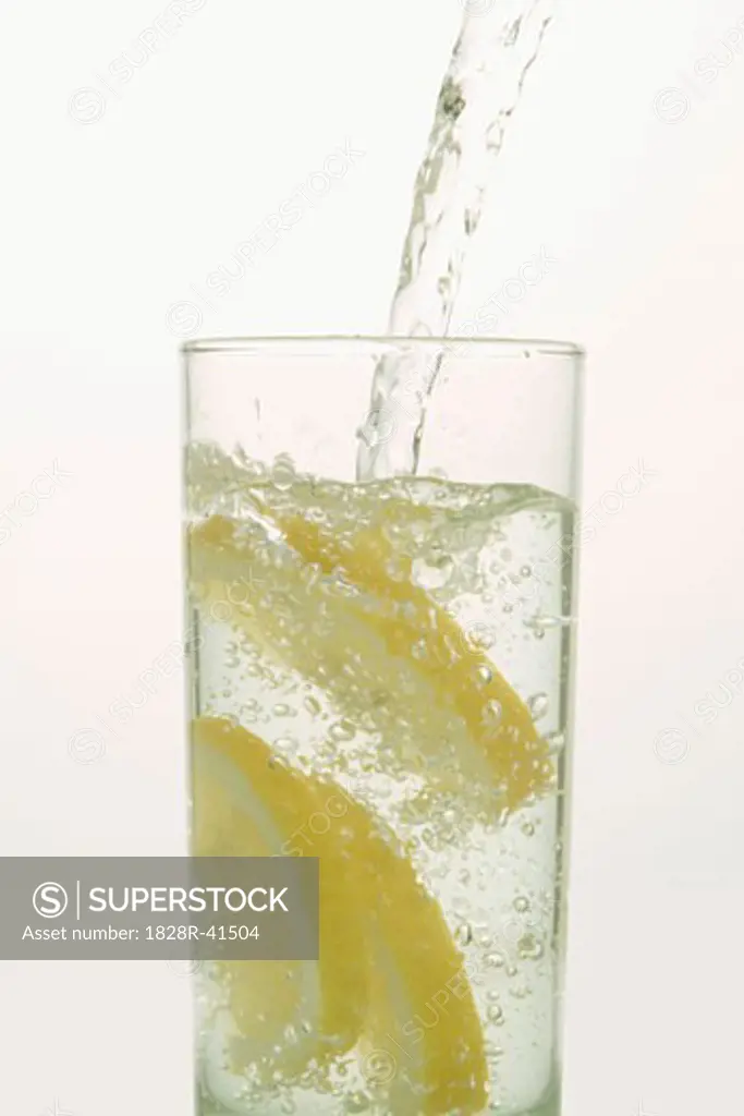 Water Pouring into Glass with Lemons   