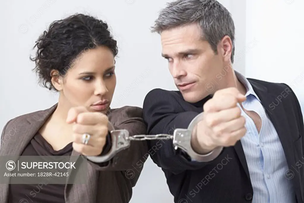 Businessman and Businesswoman Handcuffed Together   