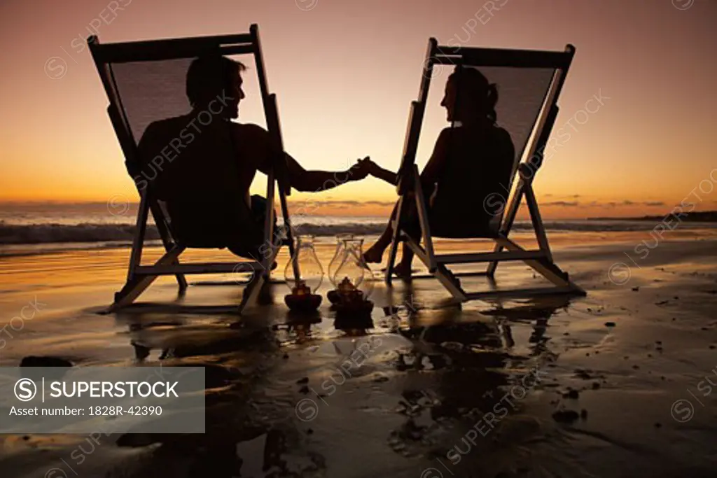Couple Sitting in Beach Chairs, on Beach at Sunset, Mexico   