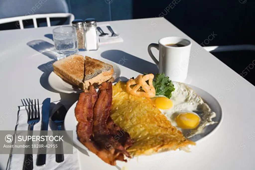 Plate of Bacon and Eggs on Table at Restaurant   