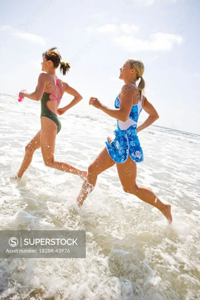 Two Young Women Running in Surf   