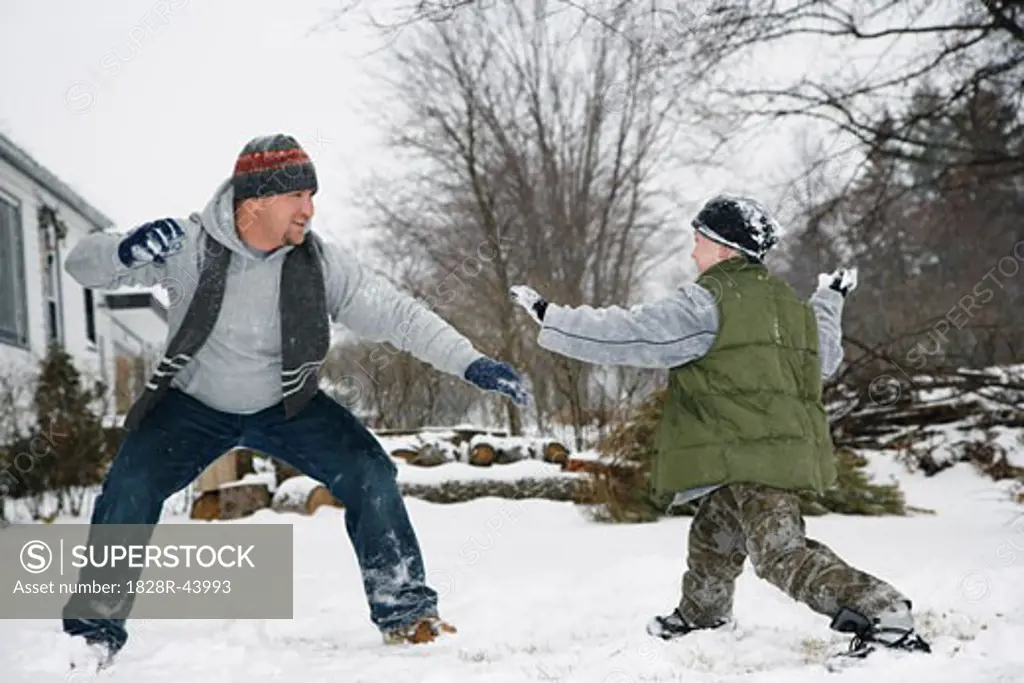 Father and Son Having Snowball Fight   