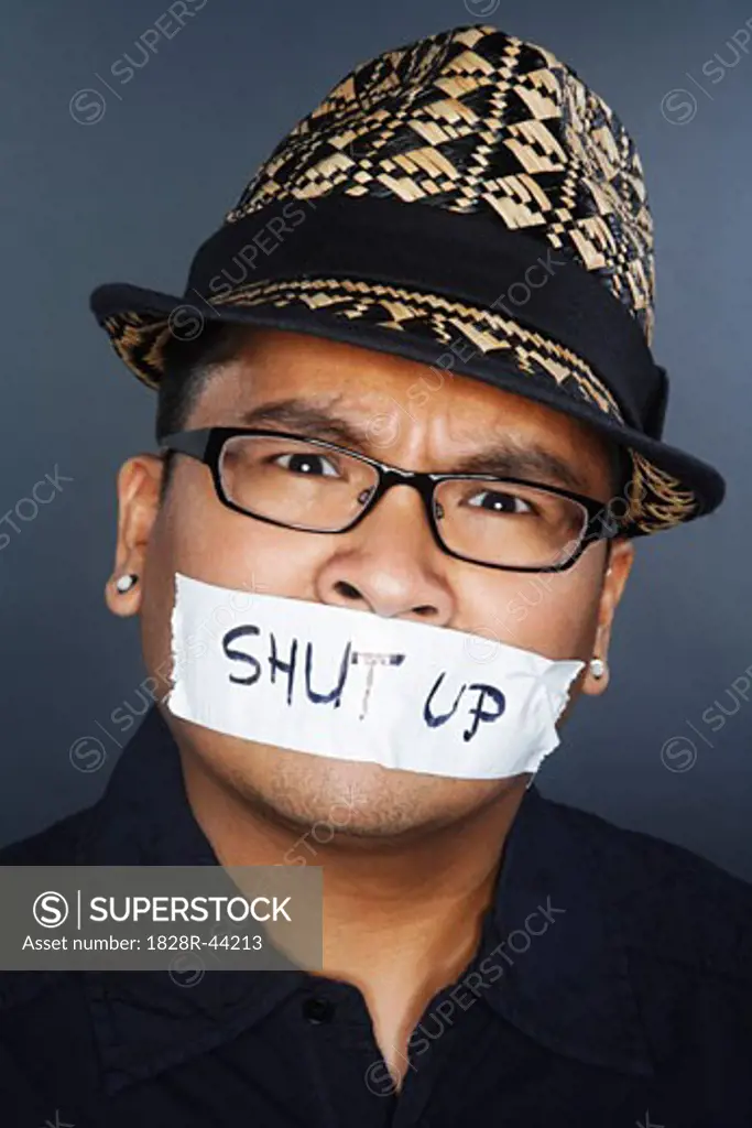 Tape With Shut Up Written on it Covering Man's Mouth   