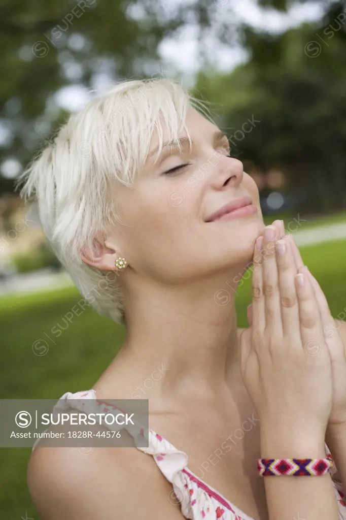 Young Woman Praying Outdoors   