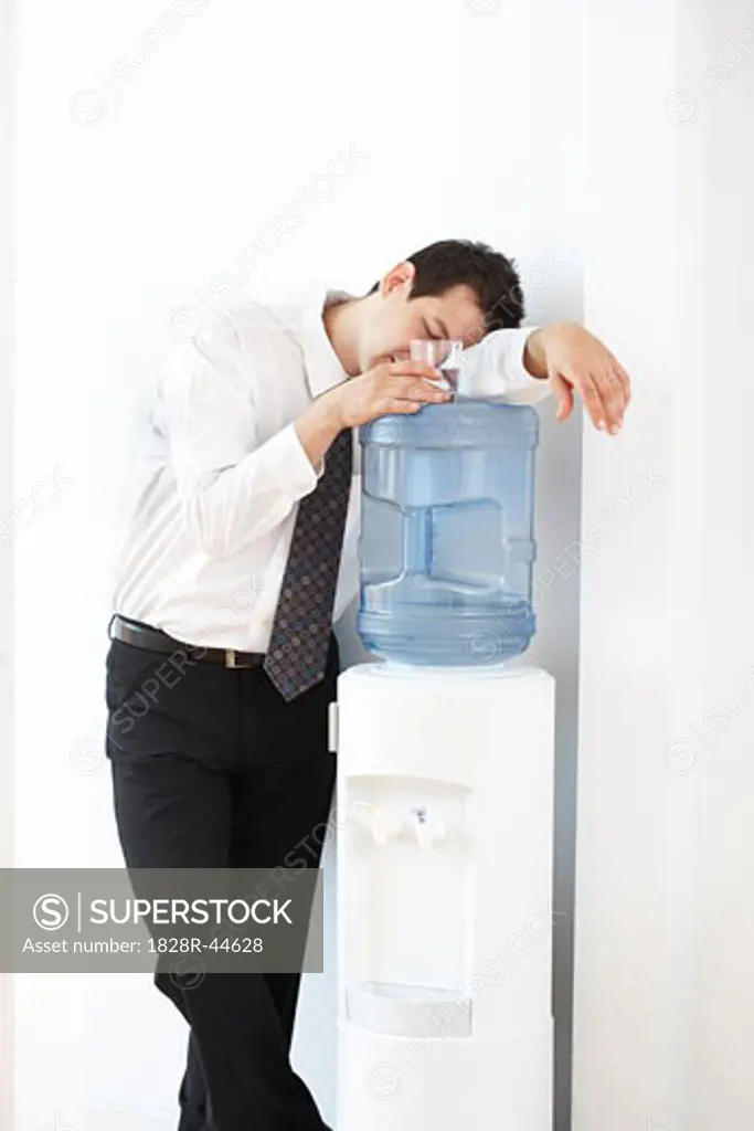 Businessman Asleep on the Water Cooler   