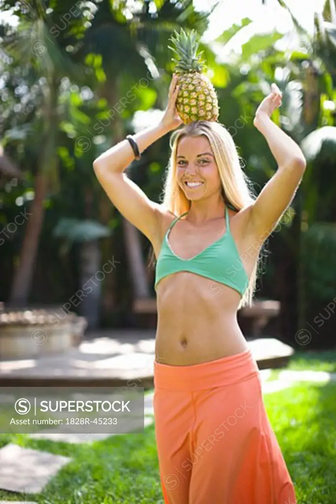 Young Woman Balancing a Pineapple on her Head   