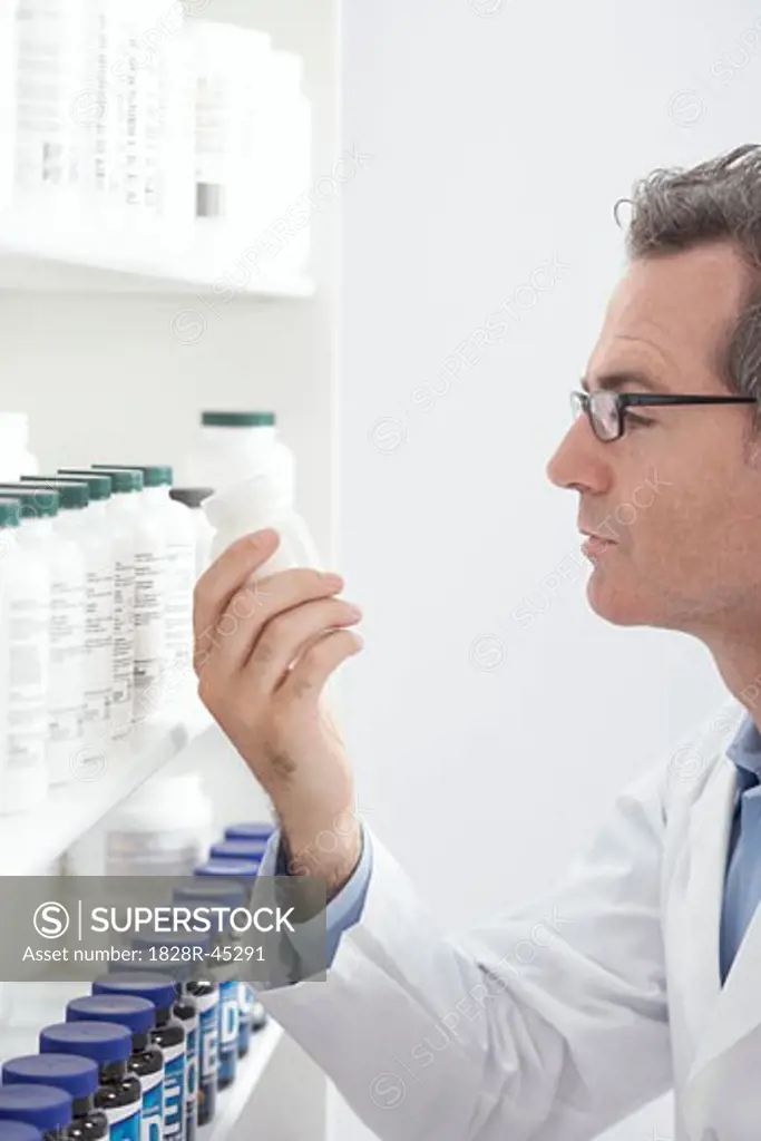Pharmacist Looking at Pills on Shelf   
