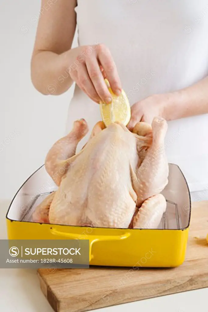 Woman Stuffing Chicken With Lemon and Garlic   