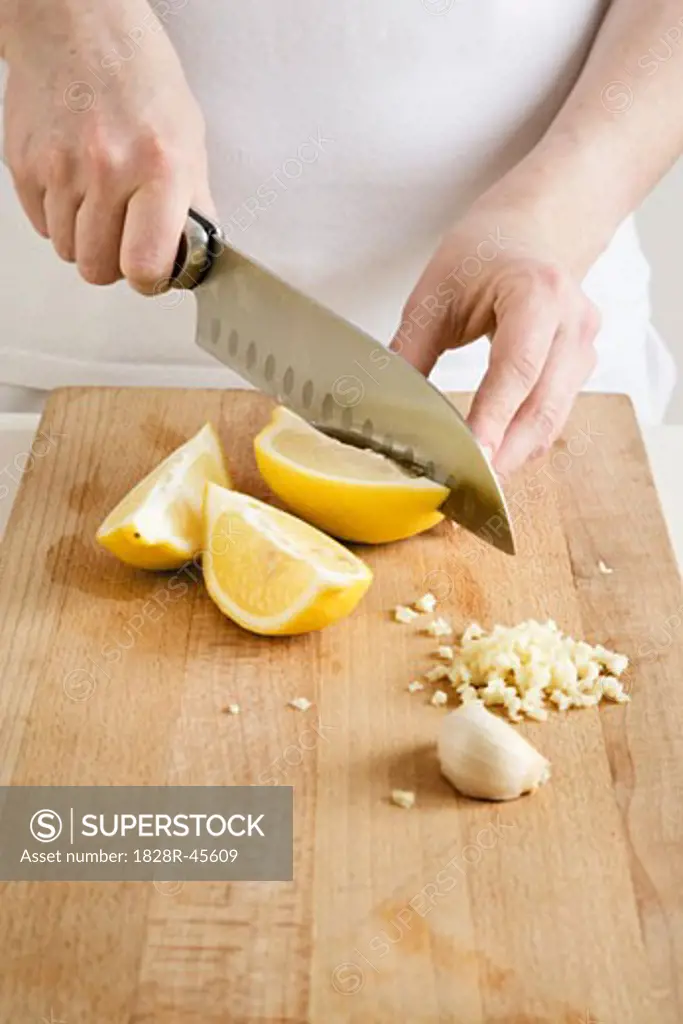 Woman Slicing Lemons and Garlic   