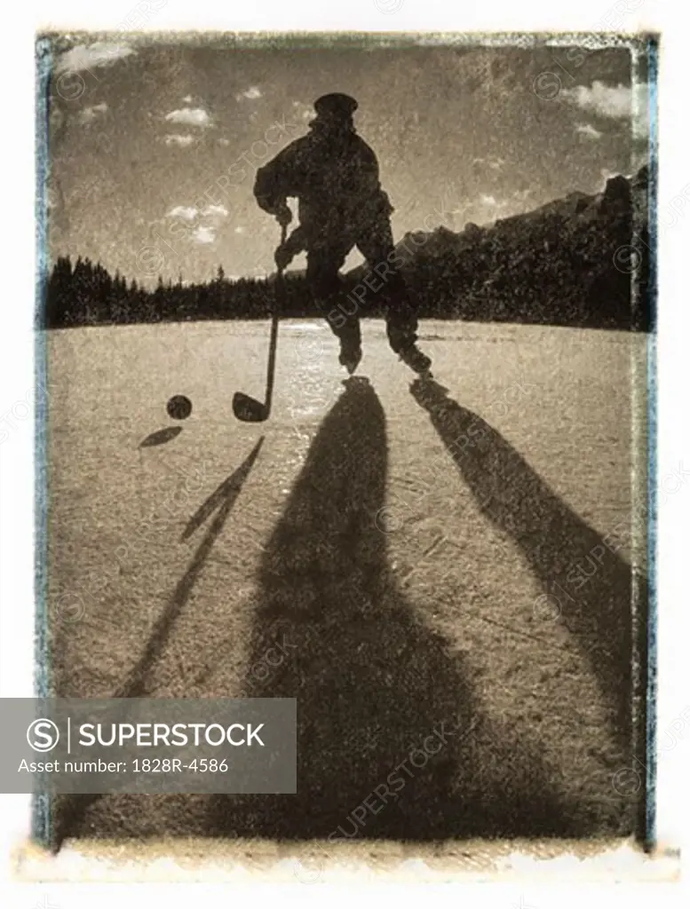 Silhouette of Man Playing Hockey Outdoors, Canmore, AB, Canada   