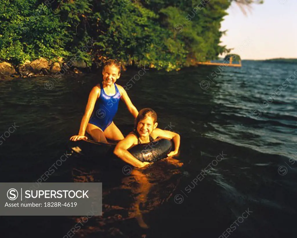 Portrait of Two Girls with Inner Tube in Lake, Maine, USA   