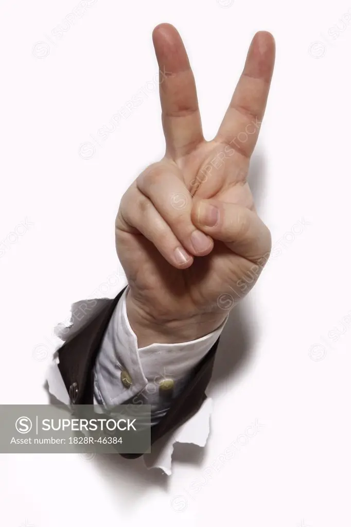 Businessman's Hand Bursting Through a Wall, Giving Peace Sign   