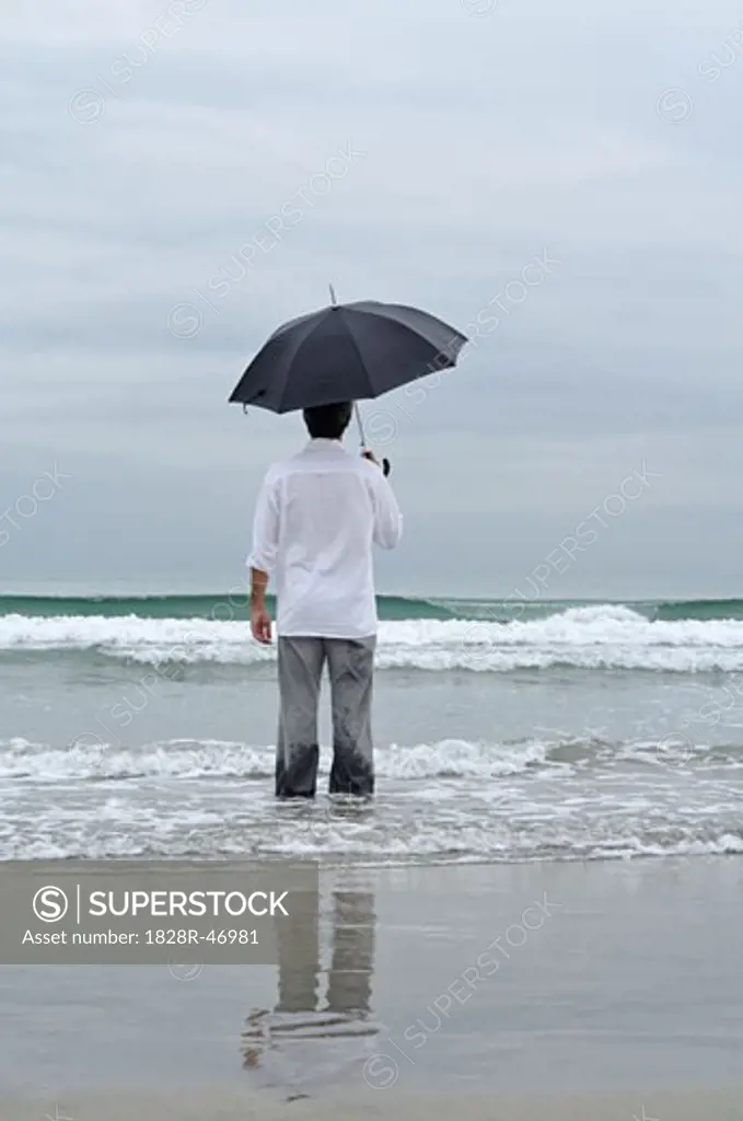 Man Holding Umbrella on Beach   