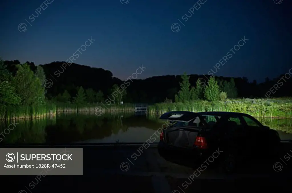 Car With Open Trunk Parked by Lake at Night   