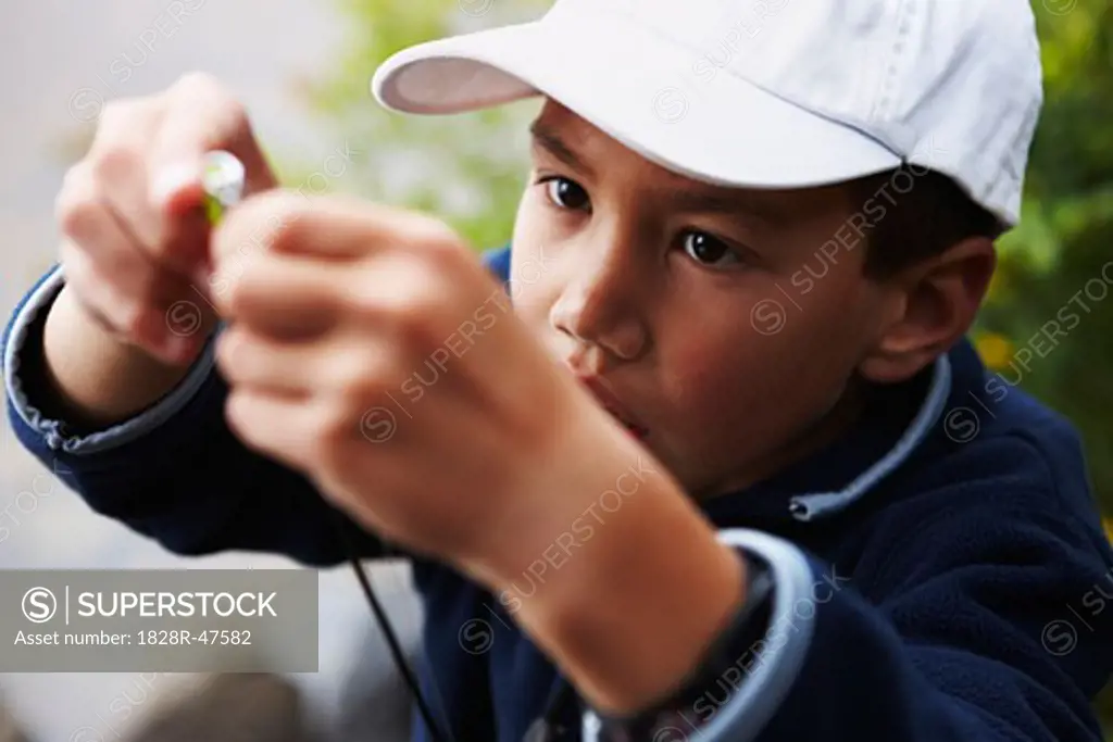 Boy Putting Lure on Fishing Rod, Algonquin Park, Ontario, Canada   