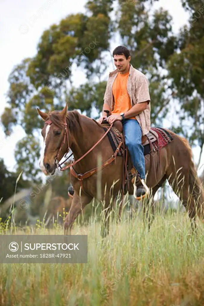 Man Horseback Riding on Ranch, Santa Cruz, California, USA   