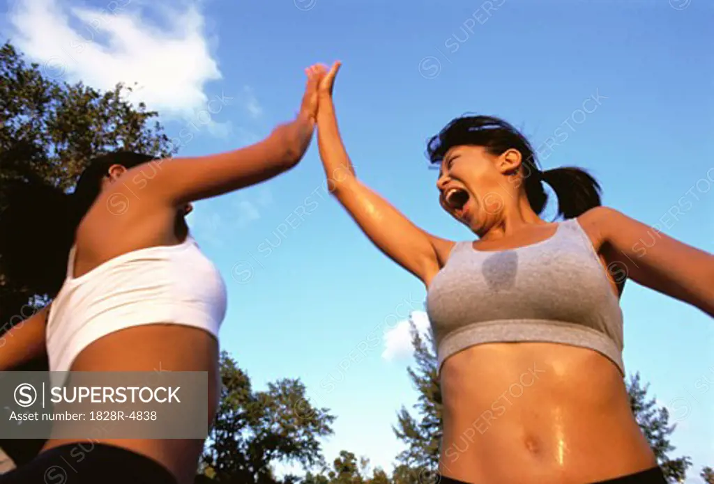 Two Women Giving High Five Perspiring Outdoors   
