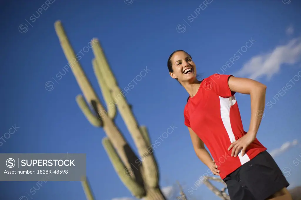 Woman Standing in Front of a Saguaro Cactus, Tucson, Arizona, USA   