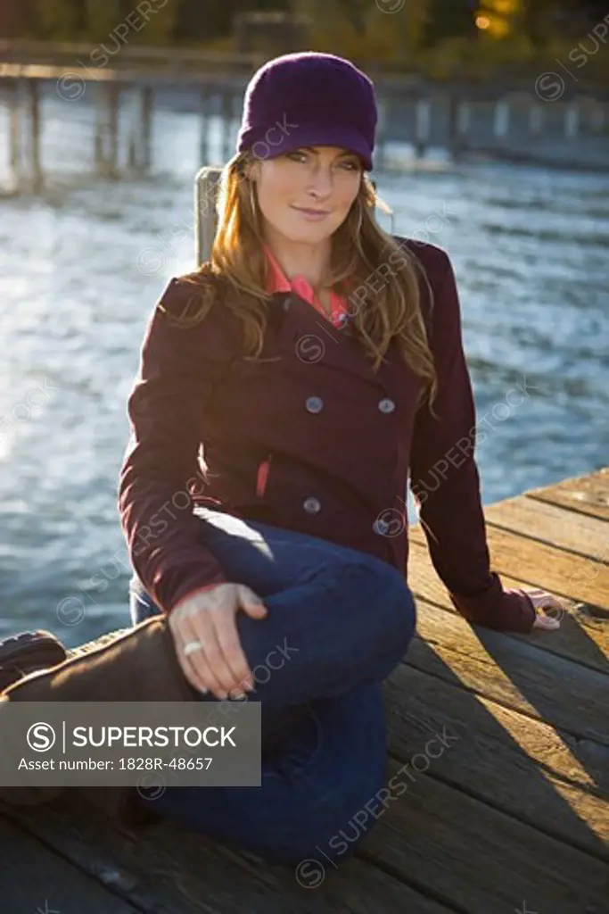 Woman Sitting On Dock by Lake   