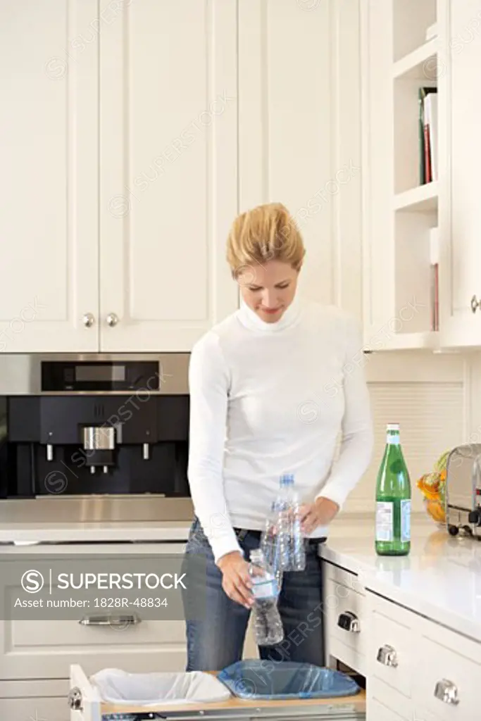 Woman Recycling Bottles in Kitchen   