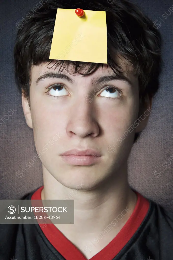 Teenager Looking at Blank Note Pinned to his Head   
