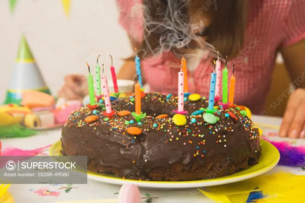 Woman Blowing Out Candles on Birthday Cake   