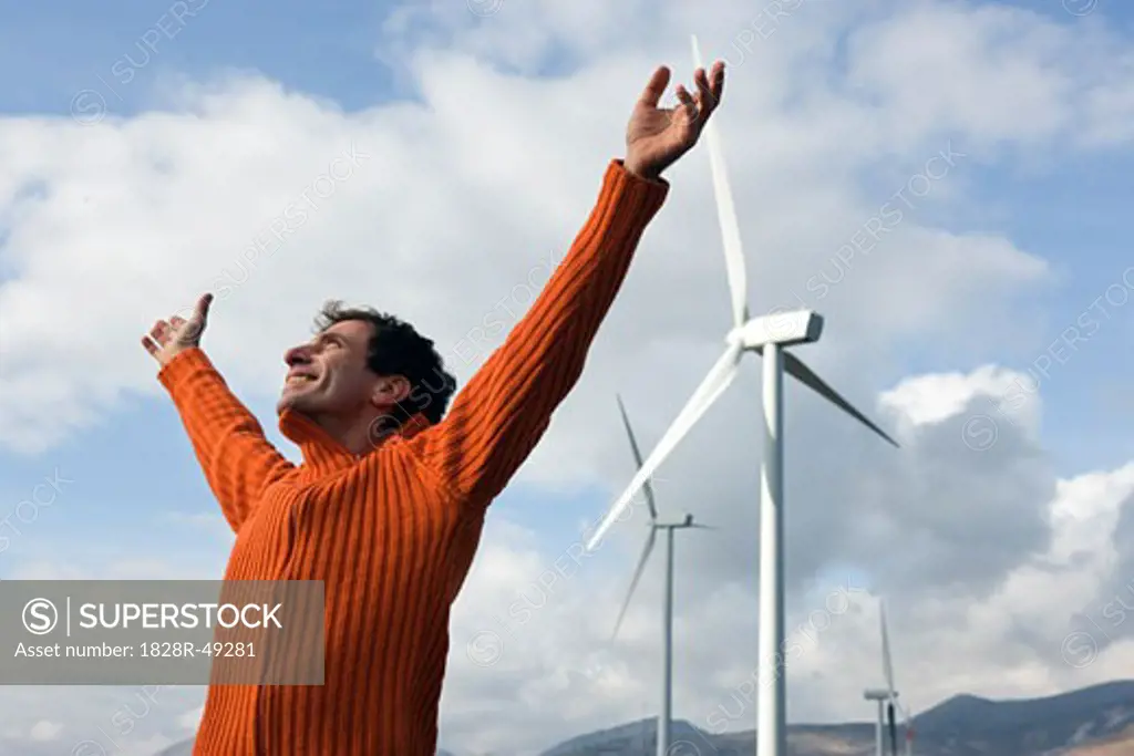Man With Arms in Air by Wind Farm   