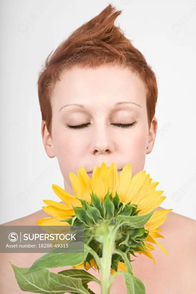 Portrait of Woman Smelling a Sunflower   