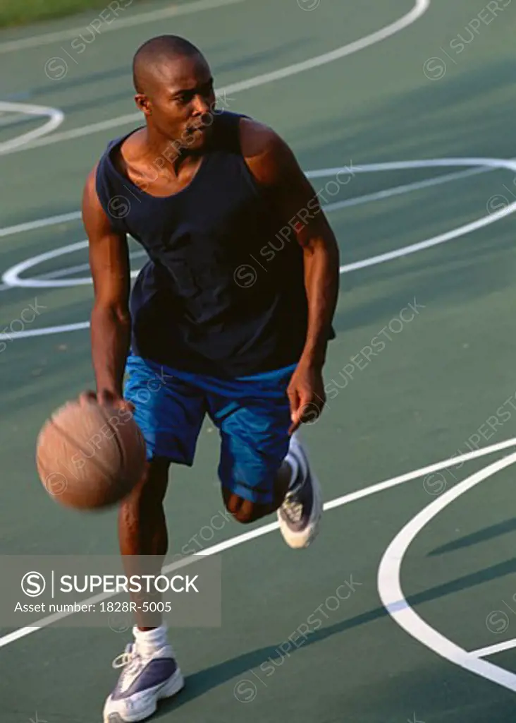 Man Dribbling Basketball Outdoors   